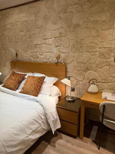 a bedroom with a bed and a table with a lamp at Savoy Hotel in Le Bourget-du-Lac
