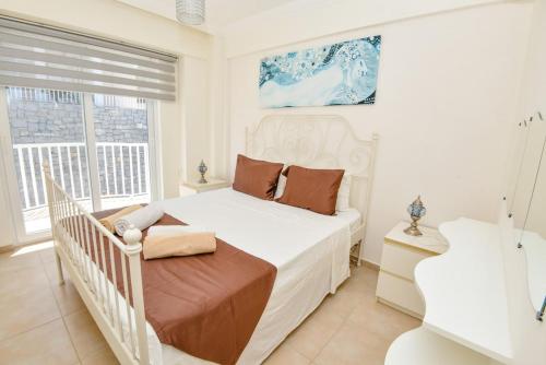 a white bedroom with a white bed and two windows at Villa Maya The Royal Links Sarigerme in Sarigerme