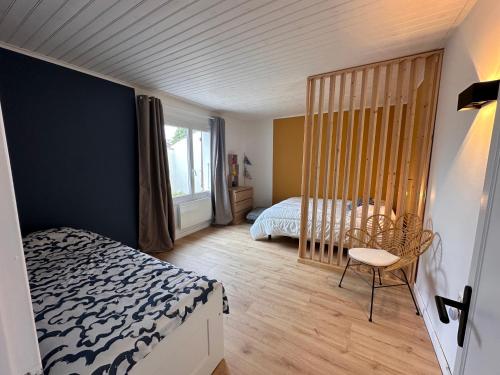 una camera da letto con un letto e una sedia di Maison centre ville La Tranche sur mer a La Tranche-sur-Mer