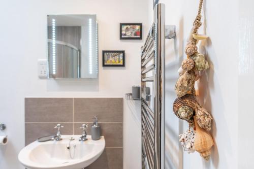 a bathroom with a sink and a mirror at Brackenhurst Cottage by Big Skies Cottages in West Runton