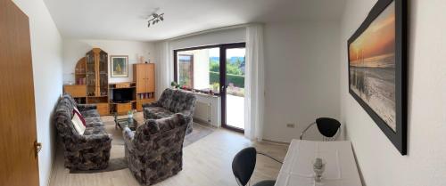 een woonkamer met twee stoelen en een tafel bij Ferienwohnung in Frielendorf in Frielendorf