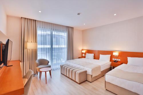 a hotel room with two beds and a television at Caddem Inn Hotel in Mağusa