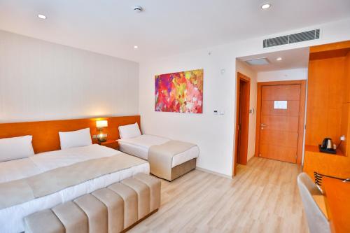 a hotel room with a bed and a couch at Caddem Inn Hotel in Mağusa
