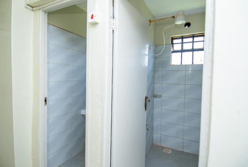 a bathroom with a shower and a glass door at Blink comfort suite- Lion in Ngong