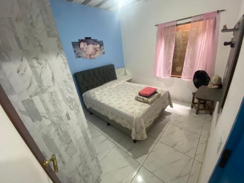 Casa Temporada Maria Antônia في باراتي: غرفة نوم صغيرة بها سرير ونافذة