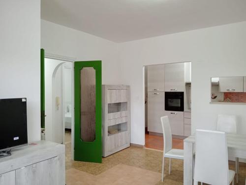 a living room with a television and a green door at Casa Toledo in Torvaianica