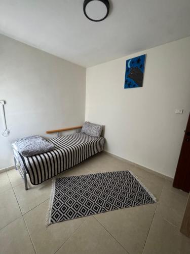 sala de estar con 2 camas y alfombra en דירת הים האדום, en Eilat