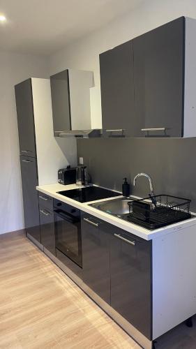 une cuisine avec un évier et un plan de travail dans l'établissement Hom & Love, Love Room BDSM, à Homécourt