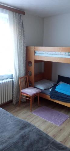 a bedroom with two bunk beds and a chair at Privat Ludmila in Liptovská Teplička