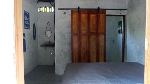 una camera da letto con un letto e una porta di legno di Suítes Águas do Estaleiro a Ubatuba