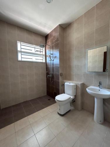 a bathroom with a toilet and a sink at Naura Homes Penang in Kampong Batu Maung