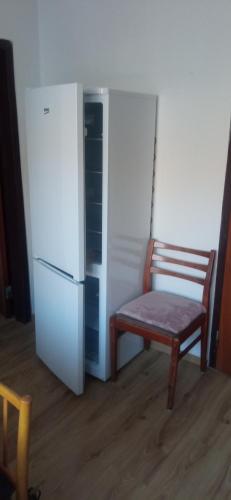 a chair and a refrigerator in a room at Privat Ludmila in Liptovská Teplička