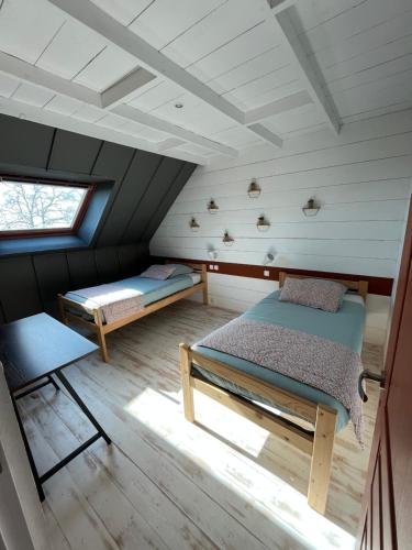 une chambre mansardée avec deux lits et une fenêtre dans l'établissement Les gîtes de Lou, entre Blois et Chambord, à La Chapelle-Saint-Martin-en-Plaine