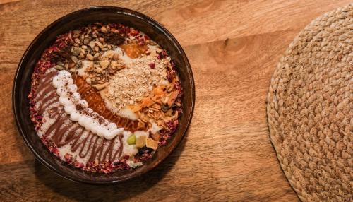 a bowl of food sitting on a wooden table at Dolkhar Resort in Leh