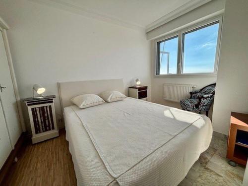 une chambre avec un grand lit blanc et une fenêtre dans l'établissement Quiberon: Studio lumineux 44m² proche centre et plage, balcon, WIFI - FR-1-478-42, à Quiberon