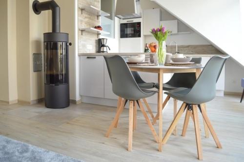 a kitchen with a wood stove next to a table and chairs at Traumkrone Ferienwohnungen - Himmelblau in Schortens