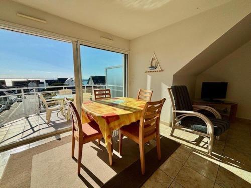 une salle à manger avec une table et des chaises et un balcon dans l'établissement Quiberon - Appartement 2P - 4 pers - Terrasse - Garage - Animaux admis - FR-1-478-79, à Quiberon