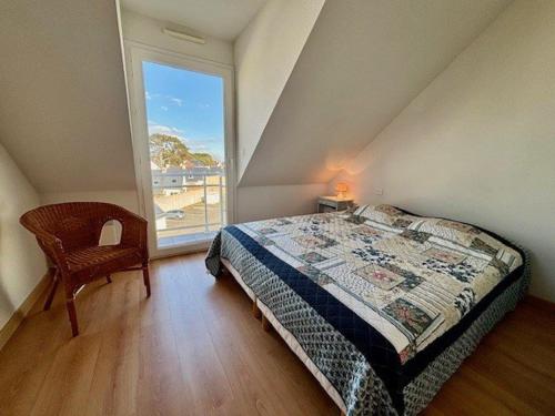 une chambre avec un lit, une fenêtre et une chaise dans l'établissement Quiberon - Appartement 2P - 4 pers - Terrasse - Garage - Animaux admis - FR-1-478-79, à Quiberon