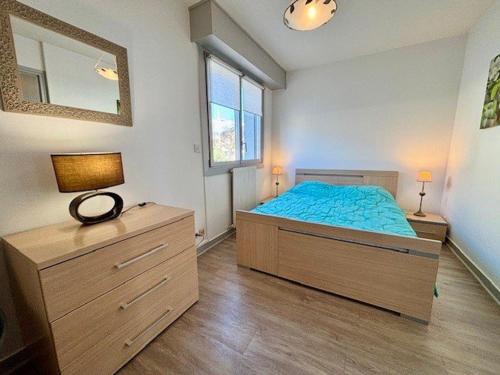 une chambre avec un lit, une commode et un miroir dans l'établissement Quiberon - Appartement 2 pièces, grande terrasse face mer, parking, animaux acceptés - FR-1-478-119, à Quiberon