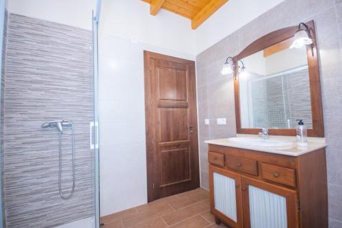 a bathroom with a sink and a shower with a mirror at Cubo's Finca La Sierra in Alhaurín el Grande