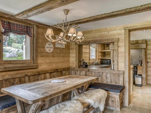 une salle à manger avec une table en bois et un lustre dans l'établissement Duplex 3 chambres avec terrasse, Wifi et parking - proche pistes - FR-1-453-216, à Megève