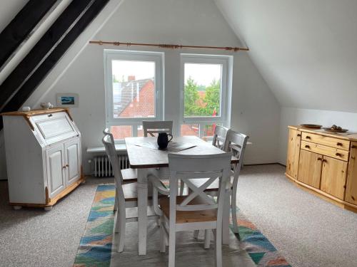 a dining room with a white table and chairs at Sandwall Whg 6 in Wyk auf Föhr