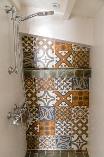 La salle de bains est pourvue d'une douche et d'un mur carrelé. dans l'établissement La Bergerie de Ferrières, à Ferrières-les-Verreries