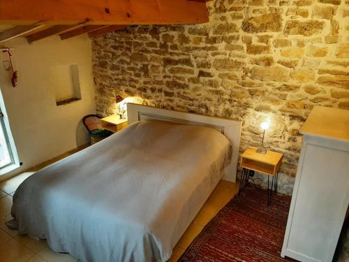 une chambre avec un lit dans un mur de briques dans l'établissement La Bergerie de Ferrières, à Ferrières-les-Verreries