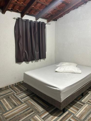 a bed in a room with a black curtain at Hostel Oásis in Itanhaém