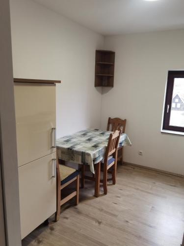 a kitchen with a table and chairs and a refrigerator at Ferienwohnung am Backhaus 6 in Weimar