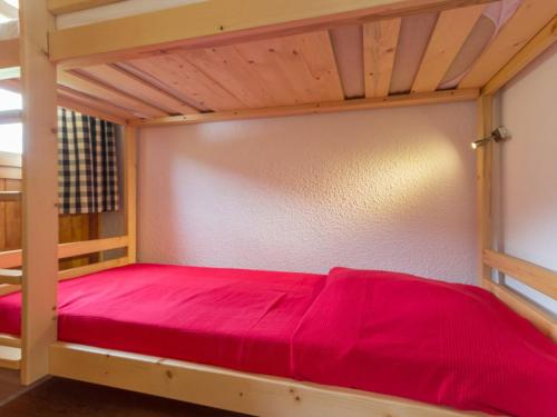 Ce lit superposé se trouve dans un dortoir doté de draps rouges. dans l'établissement Studio rénové près des pistes avec balcon - FR-1-181-2476, à La Plagne Tarentaise