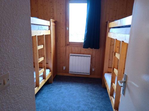 une chambre avec deux lits superposés et une fenêtre dans l'établissement Appartement Triplex 2 Pièces · Ski aux Pieds · Terrasse - FR-1-181-2624, à La Plagne Tarentaise
