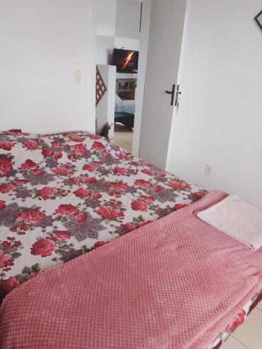 a bedroom with a bed with a red and white blanket at Quarto casal ARENA OPUS in São José