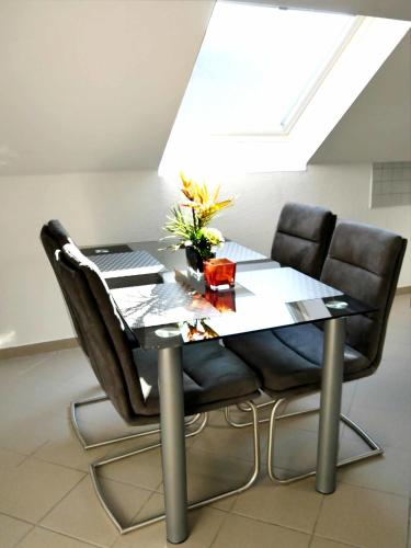 a dining room table with chairs and a laptop on it at Ferienwohnung Lenneblick in Plettenberg