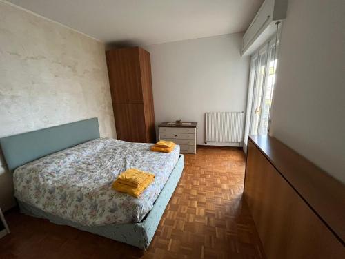 a bedroom with a bed with two yellow towels on it at Alloggio ampio zona San Martino in Sanremo