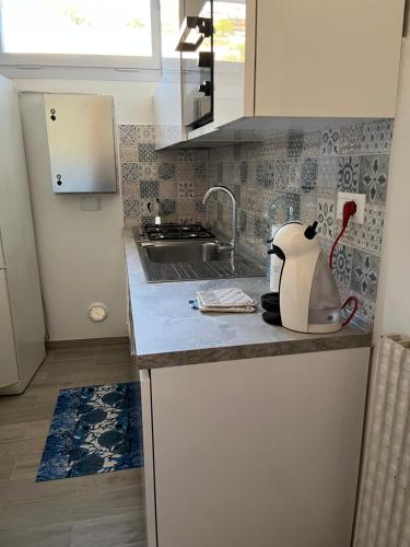 a kitchen with a sink and a kettle on a counter at Alloggio ampio zona San Martino in Sanremo