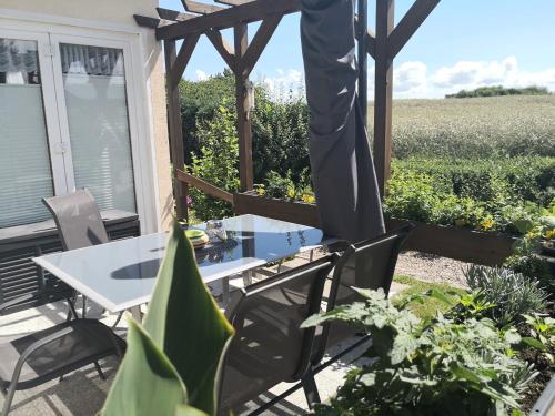 a patio with a table and chairs and a field at Zur Schwedenschanze 3 in Hohen Wieschendorf