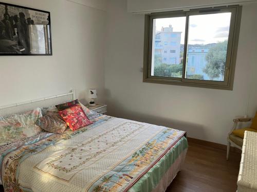 une chambre avec un grand lit avec une fenêtre dans l'établissement L'olivaie, à Antibes