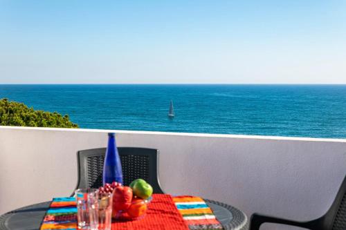 a table on a balcony with a view of the ocean at Casa Bobo in Lagoa