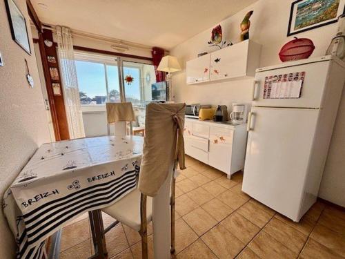 une cuisine avec une table et un réfrigérateur blanc dans l'établissement Quiberon - T3 charmant, calme, proche plage avec loggia et parking - FR-1-478-300, à Quiberon