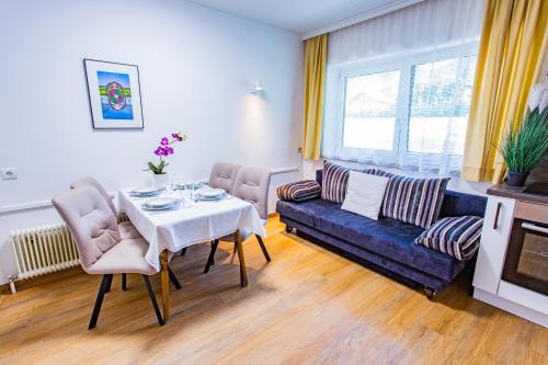 a living room with a table and a blue couch at Soldanella 6 by Alpenidyll Apartments in Ramsau am Dachstein