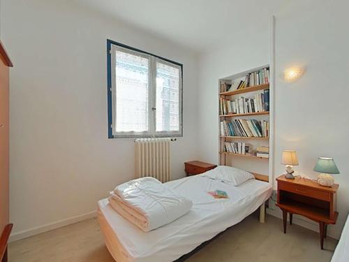 une chambre avec un lit et une étagère dans l'établissement Maison calme proche centre-ville, 3 chambres, jardin, 1,2 km de la plage - Saint-Gilles-Croix-de-Vie - FR-1-224-338, à Saint-Gilles-Croix-de-Vie