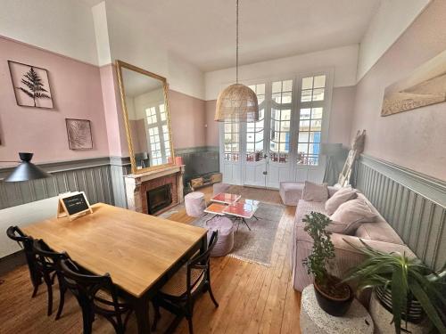 un salon avec une table et un canapé dans l'établissement Grande maison familiale - Vue latérale mer - Proximité immédiate de la Plage principale de Berck, à Berck-sur-Mer
