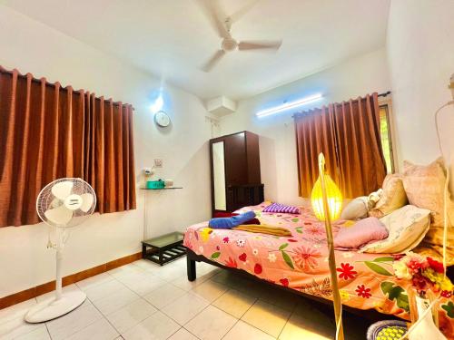 a bedroom with a bed and a fan in it at Serene Guest House ll 2 Ac Rooms ll WiFi ll Tv ll Garden in Khandala