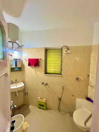 a bathroom with a toilet and a sink and a window at Serene Guest House ll 2 Ac Rooms ll WiFi ll Tv ll Garden in Khandala
