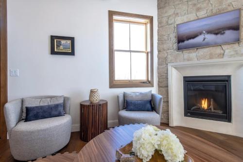 a living room with two chairs and a fireplace at Historic Homestead with Pond and Teton Range Views in Tetonia