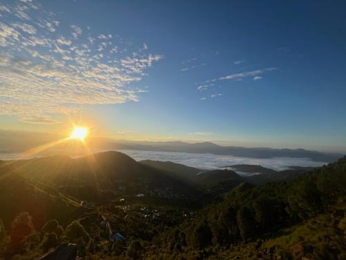 a view of the sun setting over the mountains at Ritu Raj Home Stay & Cafe in Malther