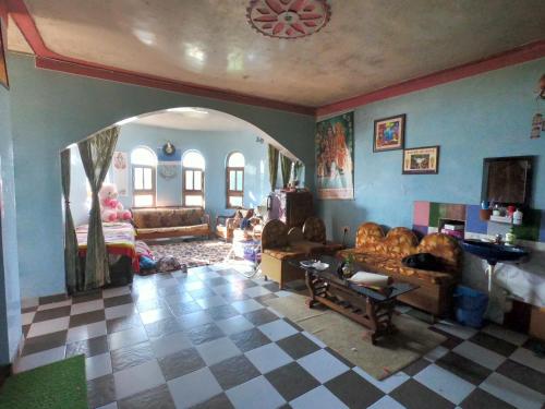 a living room with couches and a checkered floor at Ritu Raj Home Stay & Cafe in Malther
