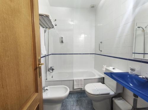 a bathroom with a tub and a toilet and a sink at Hotel Hórreo by Bossh! Hotels in Santiago de Compostela