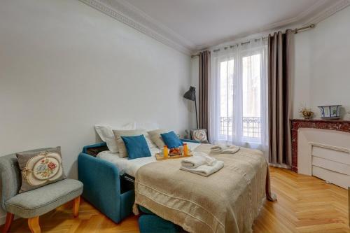 - une chambre avec un lit, une chaise et une cheminée dans l'établissement Méricourt Suite, Place de la République, à Paris